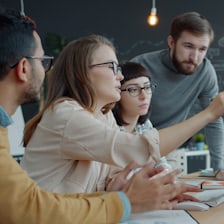 Une petite équipe réunie autour d'un écran d'ordinateur.